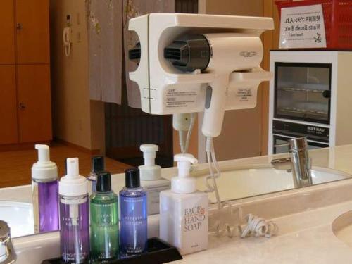 a hair dryer sitting on a sink in front of a mirror at Fuji Matsuzono Hotel in Yamanakako
