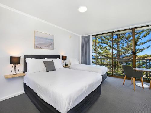 a bedroom with two beds and a large window at Boat Harbour Motel in Wollongong