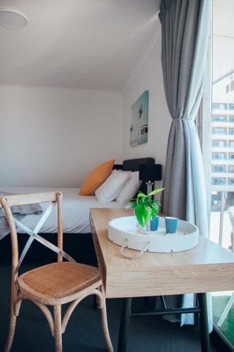 a room with a bed and a table and a chair at Boat Harbour Motel in Wollongong