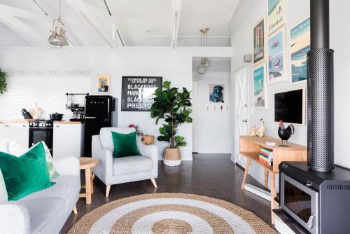 a living room with a couch and a fireplace at Thirlestane Farm Cottage & Barn in Cooroy