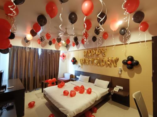 a bedroom with a bed with red and black balloons at Hotel Solitaire in Pune
