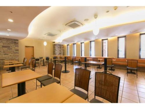 a dining room with tables and chairs and windows at R&B Hotel Kanazawa Station Nishiguchi - Vacation STAY 14972v in Kanazawa
