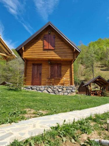 a log cabin with a porch and a grass yard at Gradine - Katun kamp in Plav