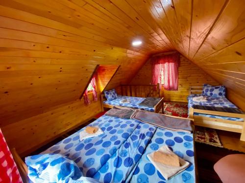 a room with three beds in a wooden cabin at Gradine - Katun kamp in Plav