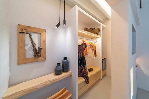 a walk in closet with wooden shelves and a mirror at F Charm all Suites - Adults Only in Líndos