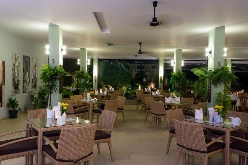 a dining room with tables and chairs and tablesktop at Austrian Garden Hotel & Restaurant Patong in Patong Beach