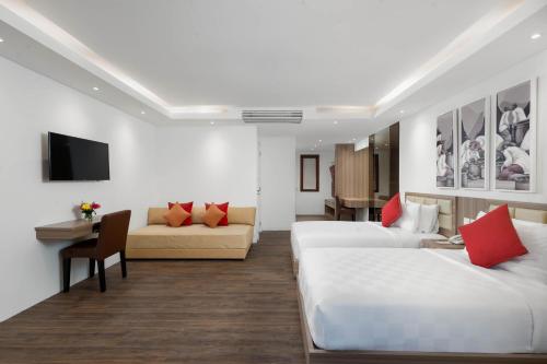 a hotel room with two beds and a couch at Downtown Villas in Seminyak
