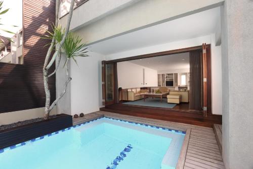 a swimming pool in a house with a living room at Downtown Villas in Seminyak