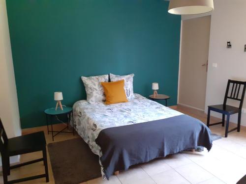 Schlafzimmer mit einem Bett mit blauer Wand in der Unterkunft La maison d'Augusta in Saint-Martin-de-Coux