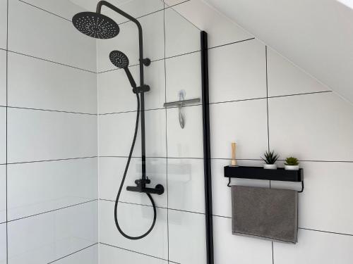 a shower in a bathroom with white tiles at Vakantiehuis Sahara119 in Lommel