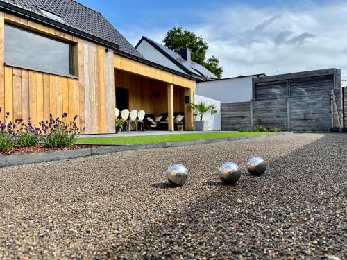 three silver balls sitting on the ground in front of a house at Vakantiehuis Sahara119 in Lommel
