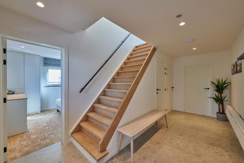 a staircase in a home with white walls and a stair bench at Vakantiehuis Sahara119 in Lommel