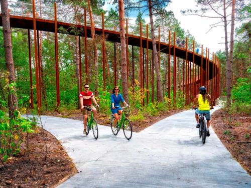 three people riding bikes on a path under a bridge at Vakantiehuis Sahara119 in Lommel