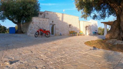 a red bike parked in front of a building at Trullo Nadia Ostuni in Ostuni