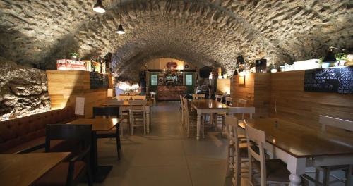 un restaurante con mesas y sillas de madera en un túnel en Palazzo Badiale history&rooms en Atella