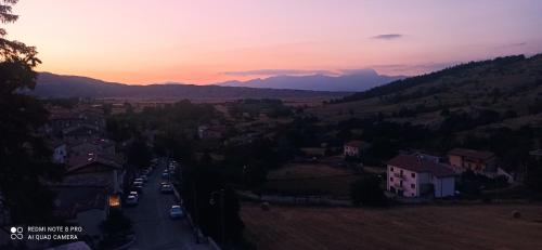 a view of a town at sunset with cars driving down a road at B&B Il Cardinale in Rocca di Mezzo