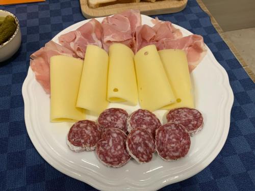 a plate of sausage and cheese on a table at B&B D'Amari Affittacamere in Palermo
