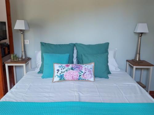 a bed with blue pillows and a pillow on it at Casa La Quercia- Tra Cefalù ed il Parco delle Madonie in Gratteri