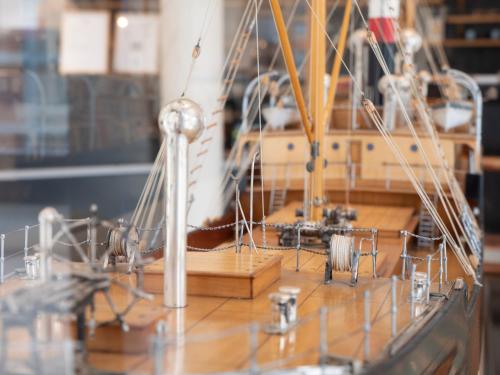 a model of a boat on a wooden table at Hotel Frederikshavn in Frederikshavn