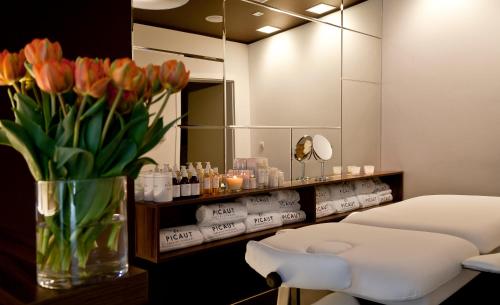 a salon with a vase of flowers and a mirror at Hotel Hanza in Gdańsk