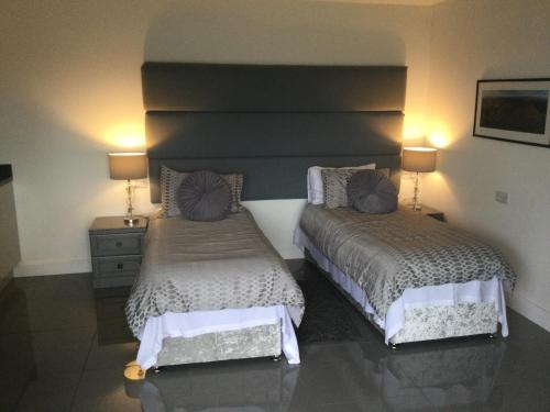 two beds in a hotel room with two lamps at The Smithy in Hay-on-Wye