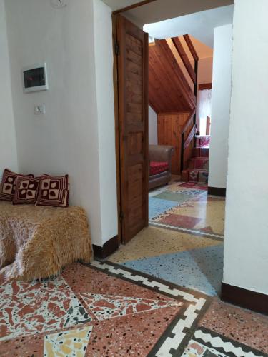 a bedroom with a bed in a room with a door at Guest House Salaria in Gjirokastër
