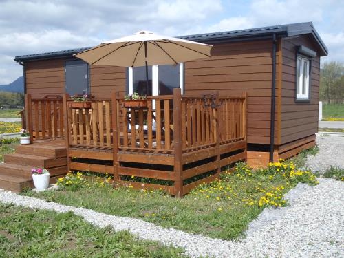 a small cabin with an umbrella on a deck at Amis apartmán 2 in Liptovský Trnovec
