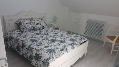 1 dormitorio con 1 cama con colcha de flores en Les Cavelots à Vendôme, en Vendôme