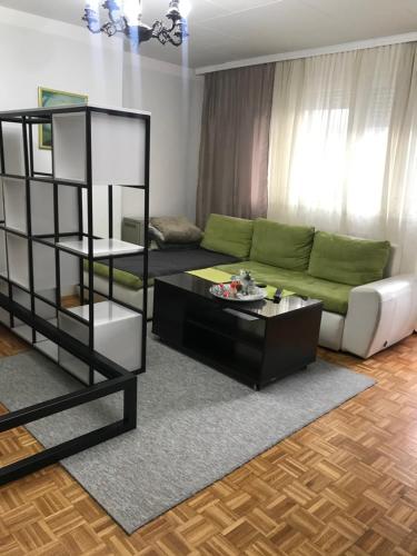 salon z kanapą i stołem w obiekcie Dan i noc w mieście Banja Luka