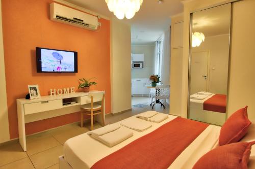 a hotel room with a bed and a tv on the wall at 1926 Designed ApartHotel in Haifa