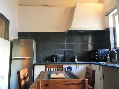 une cuisine avec une table en bois et un réfrigérateur dans l'établissement Sète Criée, à Sète