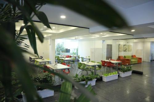 a large room with tables and chairs and plants at SwanSuites Gachibowli in Hyderabad