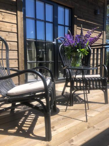 two chairs and a vase of purple flowers on a porch at Hotell Viktors in Sälen
