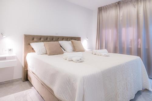 a bedroom with a large white bed with towels on it at Luxury rooms Green and Gold Split in Split