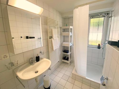 uma casa de banho branca com um lavatório e um chuveiro em Seeblick an Luxusmeile 4P, 70m2 - Parkplatz, - S11-1 em St. Moritz