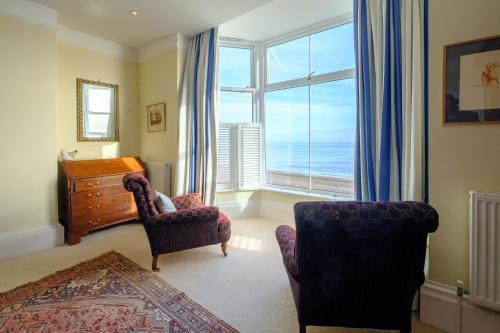 a living room with a view of the ocean at Gunfleet, Aldeburgh - A Large Seafront House with Stunning Sea Views from all the floors, Sleeps 14 - Aldeburgh Coastal Cottages in Aldeburgh