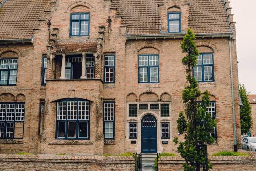 een oud bakstenen gebouw met een blauwe deur bij Blauwe Huis B&B in Nieuwpoort