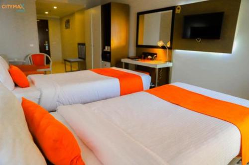 a hotel room with two beds and a television at Citymax Hotel Aswan in Aswan