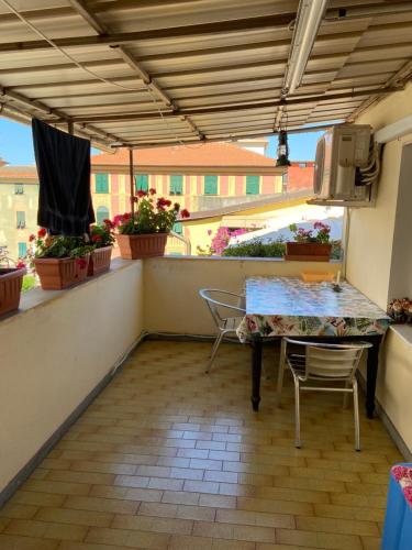 een patio met een tafel en stoelen op een balkon bij COME a CASA TUA - LAVAGNA in Lavagna