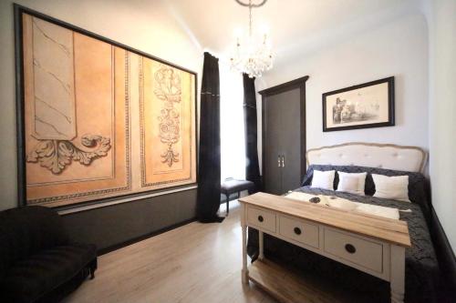 sypialnia z łóżkiem ze stołem i żyrandolem w obiekcie Dimora dell'Antico Convento w Albie