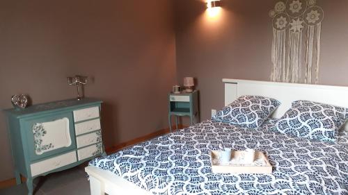Schlafzimmer mit einem Bett mit einer blauen und weißen Bettdecke in der Unterkunft au fil du temps perdu in Wismes