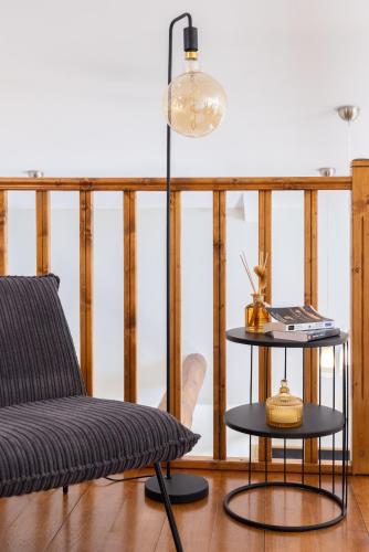 une chambre avec une chaise, une table et une lampe dans l'établissement Loft tout équipé au cœur d'un domaine viticole, à Campsas