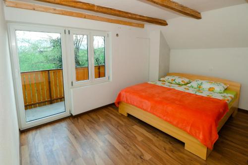 1 dormitorio con cama y ventana grande en Apartment Organic Farm Hvadnik, en Tržič