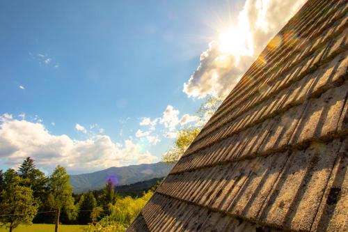 a roof of a building with the sun behind it at Apartment Organic Farm Hvadnik in Tržič