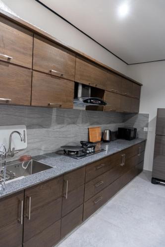 a kitchen with wooden cabinets and a sink at Trivelles Executive Suites Islamabad in Islamabad