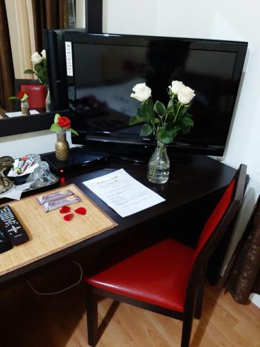 a desk with a vase of white flowers on it at Pensiunea Caramell in Cluj-Napoca