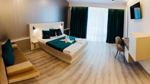 a bedroom with a bed and a desk and a chair at Vila Ursul Negru in Sovata