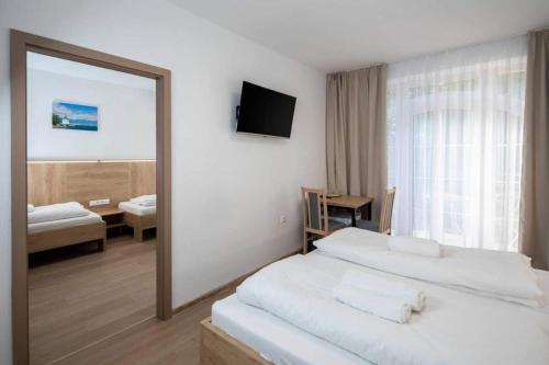 a bedroom with two beds and a large mirror at Penzion Zuzana in Ružomberok