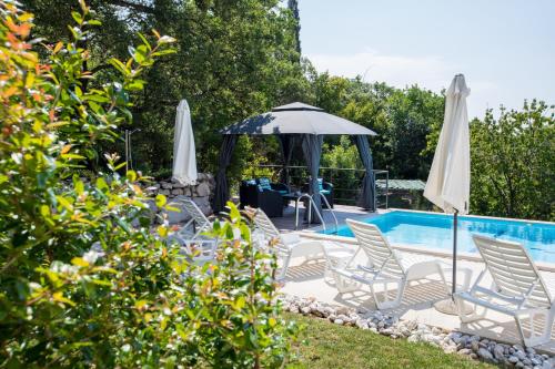 a pool with chairs and a gazebo at Villa Luce Konavoka in Čilipi