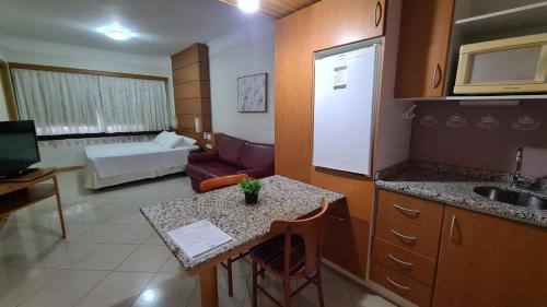 a room with a kitchen and a living room at Costa Sul Beach Hotel in Balneário Camboriú